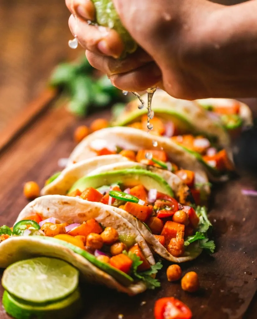 Vegetarian tacos on a wooden board with fresh lime