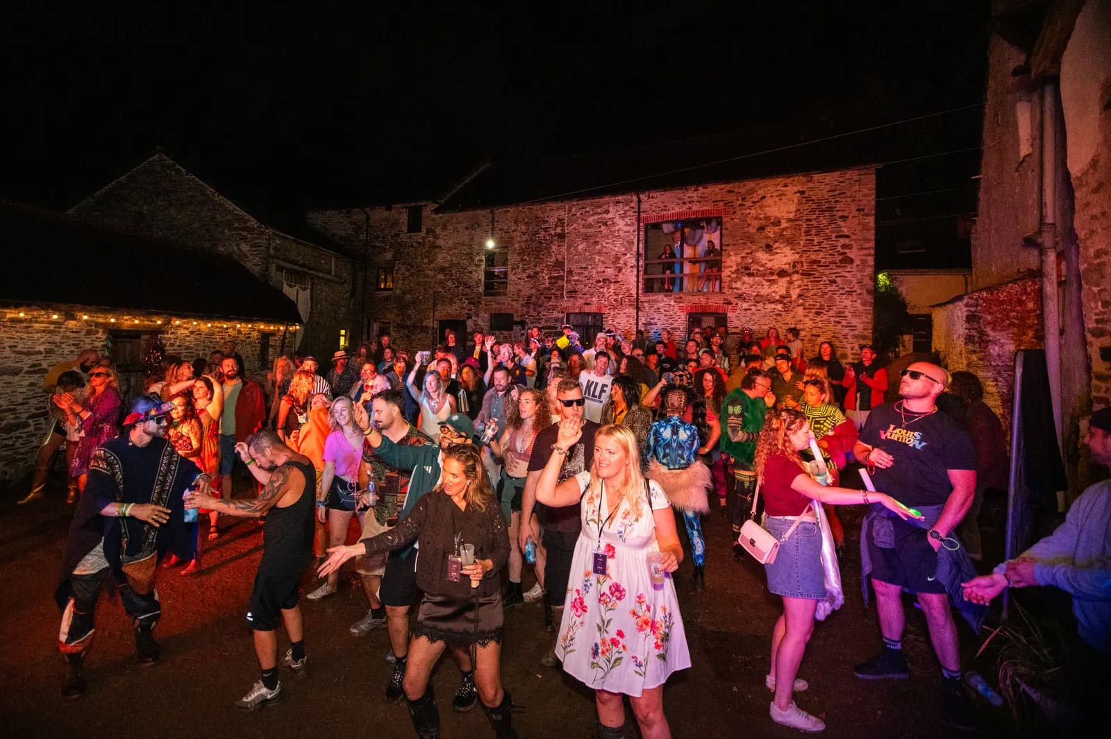 Crowd dancing in the stone courtyard at night